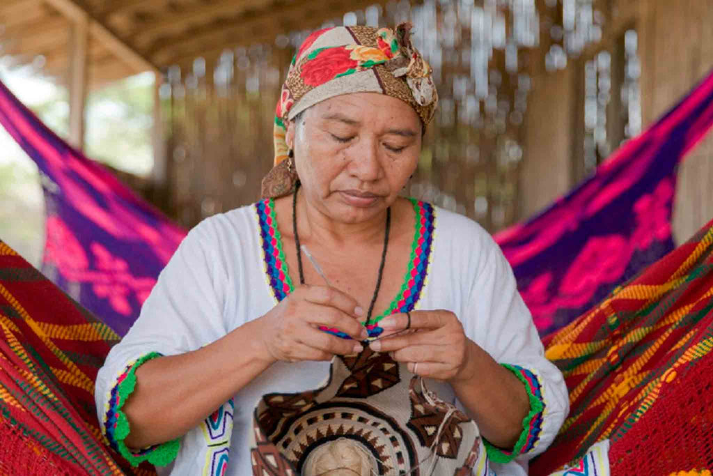 Indigena wayú tejiendo un bolso típico de su comunidad